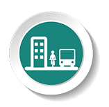 An icon representing public transportation, showing a figure standing next to a bus and a building in a circular teal and white design.